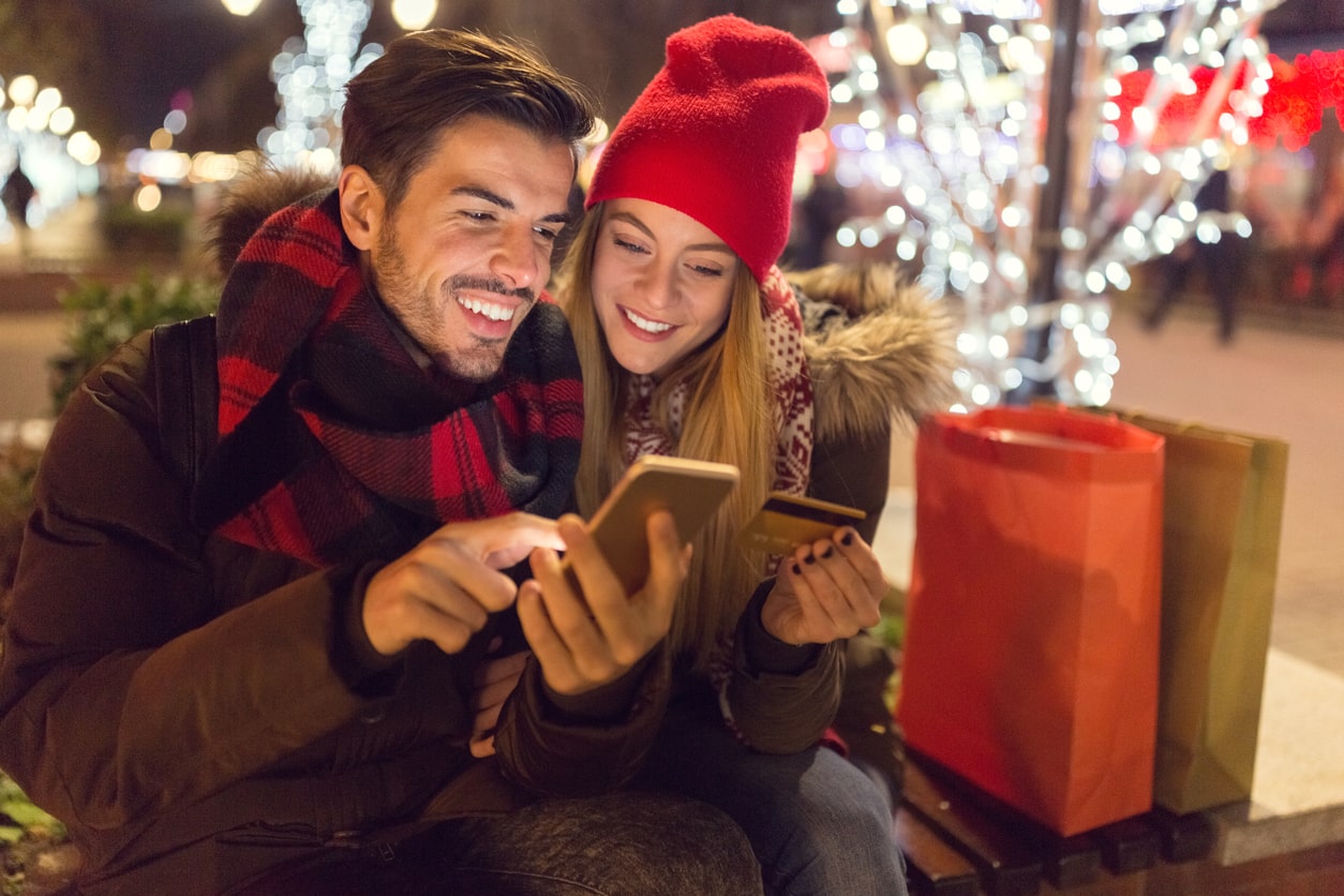 Happy family shopping online for Christmas stock photo | Ζευγάρι με κινητά και κάρτα ψωνίζουν για τα Χριστούγεννα