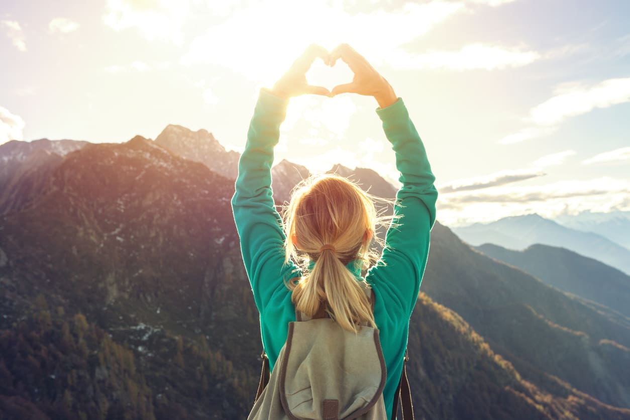 Eurolife blog - climber woman at a mountain making a heart shape with her hands