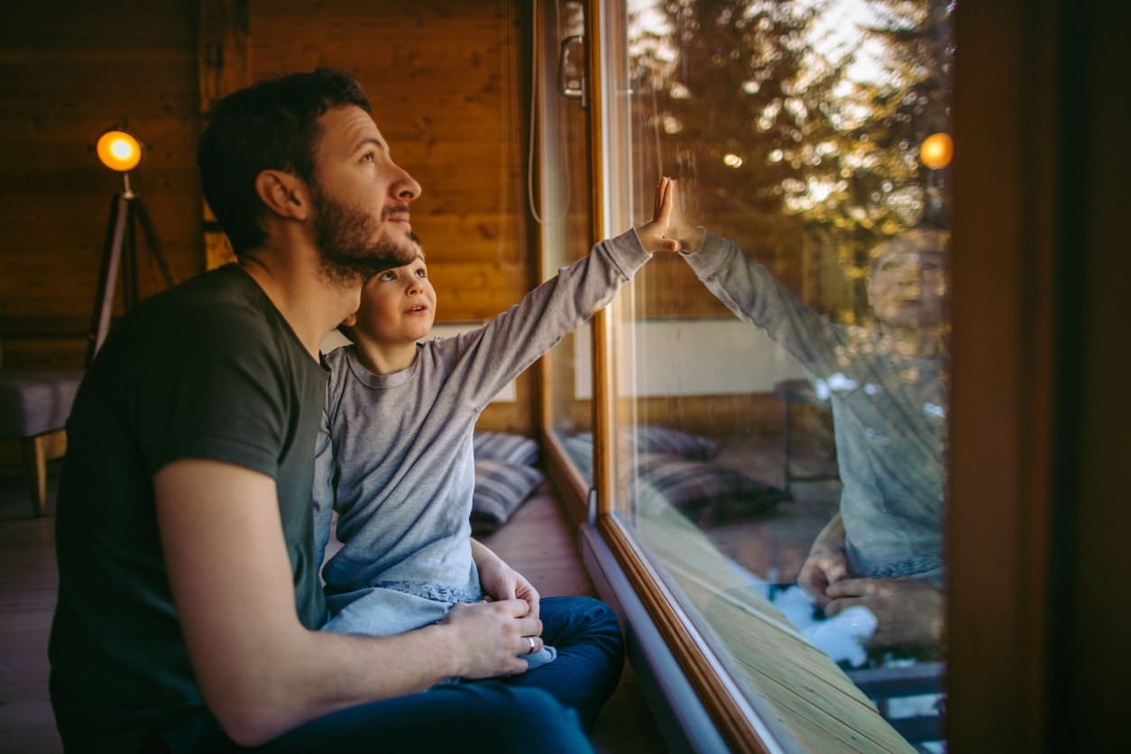 Father and child looking out of a window