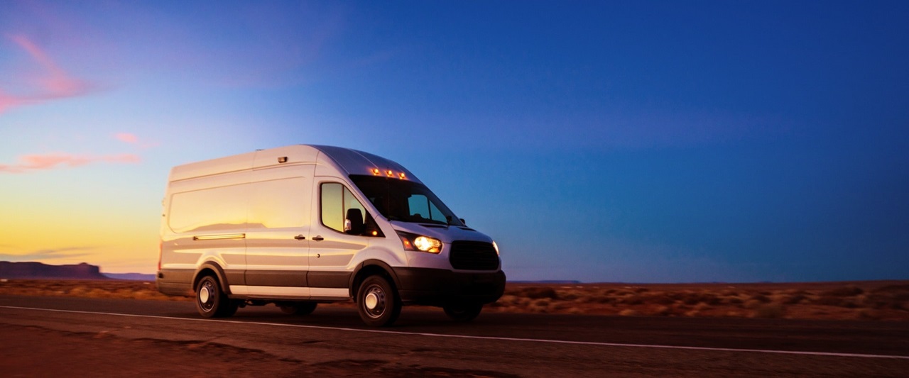 white-delivery-van-driving-on-rural-road